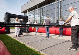 Kaufen Sie ein schwarz-rotes Tischfußballspiel mit einzigartigem Einstiegs-Schiebesystem ohne Boden für Kinder.